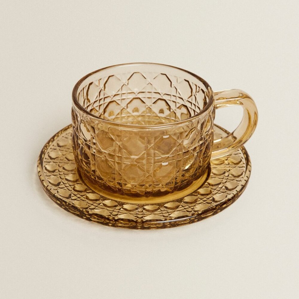 GLASS TEACUP AND SAUCER WITH RAISED GEOMETRIC DESIGN